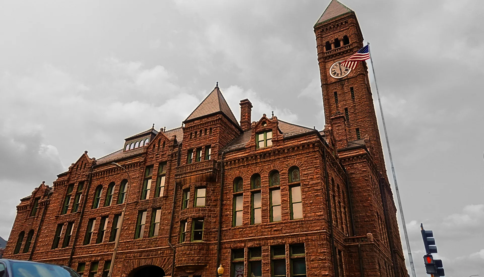 The Old Minnehaha County Courthouse in Sioux Falls, built of Sioux quartzite, its arched entrance and window frames trimmed in weathered copper.